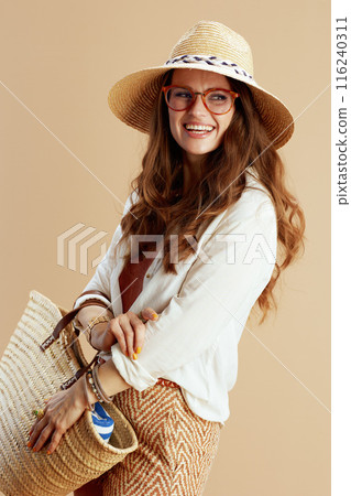 smiling stylish female in blouse and shorts against beige 116240311