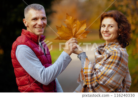 Portrait of happy stylish couple in park with autumn leaf Portrait of happy stylish couple in park with autumn leaf 116240330