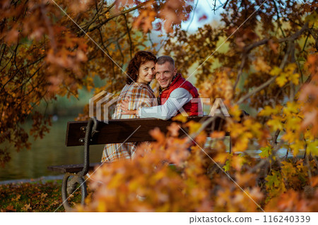 smiling modern family in park sitting on bench smiling modern family in park sitting on bench 116240339