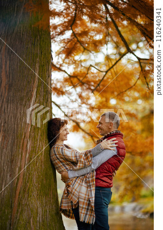 smiling romantic couple in park embracing near tree 116240341