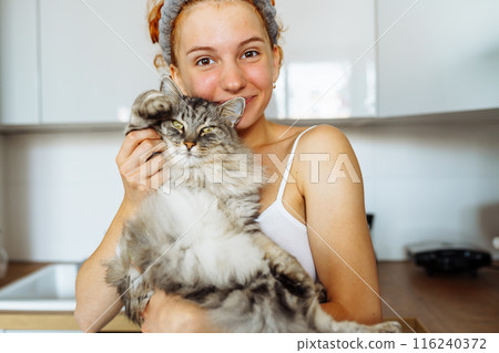 portrait red-haired teenage girl with gray fluffy cat 116240372