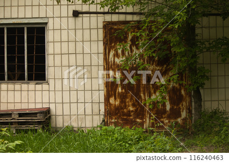 old abandoned building, broken window and rusty metal old door 116240463