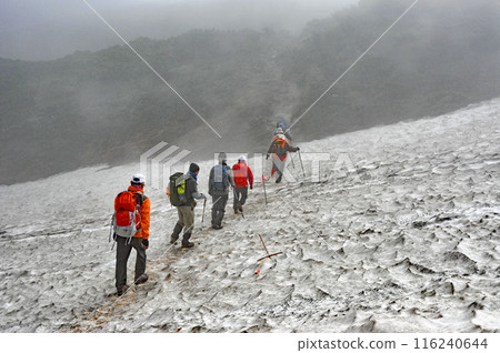 Hokkaido, Daisetsuzan traverse, trekkers crossing the snowy valley of Susoai-daira Hokkaido, Daisetsuzan traverse, trekkers crossing the snowy valley of Susoai-daira 116240644
