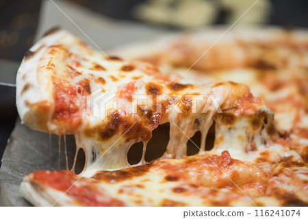 Tasty slice of pizza with pepperoni, and other types of cheese. Cheese pull, quattro formaggio. 116241074