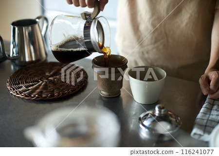 Pouring finished coffee into a cup Pouring finished coffee into a cup 116241077