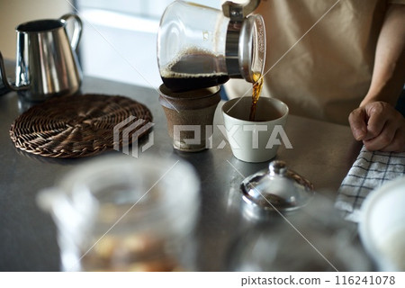 Pouring finished coffee into a cup Pouring finished coffee into a cup 116241078