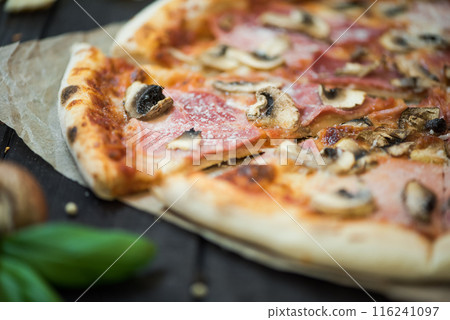 Delicious pizza with cheese, ham and mushrooms. Pizza with a thick side, Italian style. 116241097