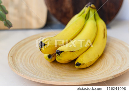 Ripe delicious bananas on a wooden plate. Ripe delicious bananas on a wooden plate. 116241098