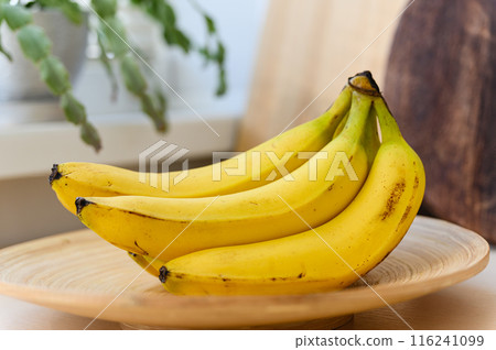 Ripe delicious bananas on a wooden plate. 116241099