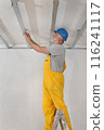 Senior adult worker fixing aluminum batten for gypsum ceiling 116241117