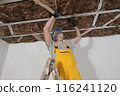 Senior adult worker apply insulation for gypsum ceiling 116241120