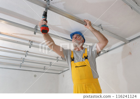 Senior adult worker fixing aluminum batten for gypsum ceiling Senior adult worker fixing aluminum batten for gypsum ceiling 116241124