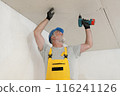 Senior adult worker fixing gypsum ceiling using screwdriver 116241126