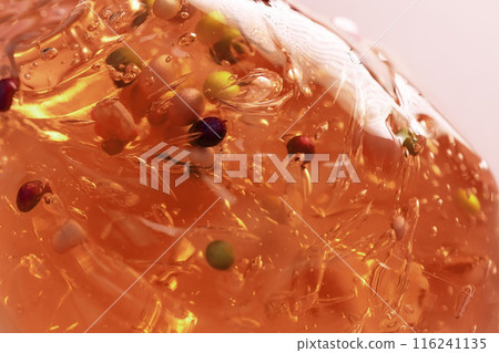 Colorful gel texture, clear skincare cream with bubbles and decorative figurines background, transparent beauty serum, colored cosmetic product close up 116241135