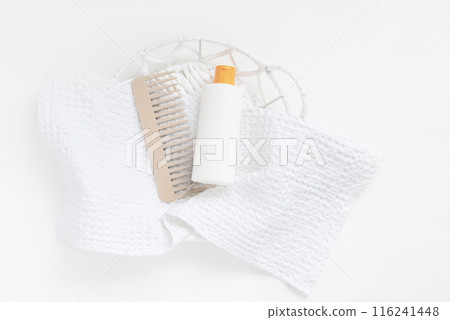 Plastic white bottle hair comb on towel. Mockup template for hair care products. Plastic white bottle hair comb on towel. Mockup template for hair care products. 116241448