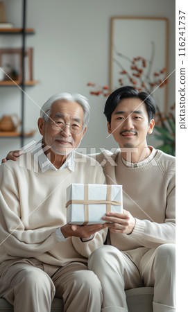 A son gives his father a gift, beautifully packaged in a box. Strong family ties 116241737