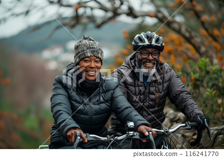 Happy old couple cycling mountain bikes in forest 116241770