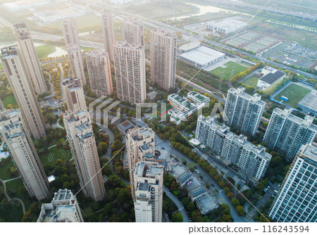 An aerial view of a modern city skyline at sunset, showcasing numerous high-rise buildings. An aerial view of a modern city skyline at sunset, showcasing numerous high-rise buildings. 116243594