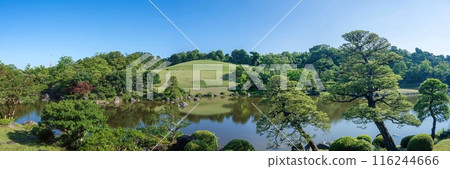 Panoramic view of a Japanese garden surrounded by fresh greenery against a blue sky Panoramic view of a Japanese garden surrounded by fresh greenery against a blue sky 116244666