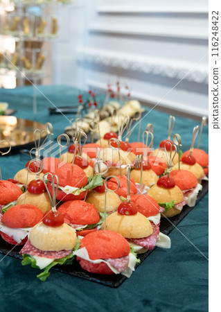 Mini Small burgers served on one plate as appetizers .  116248422