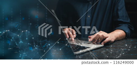 Focused professional working on cybersecurity strategies on laptop with digital security icons 116249000