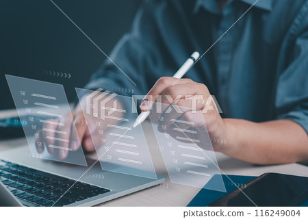 Close-up of hands using a futuristic interface for task management, and digital checklist satisfaction on a laptop. 116249004