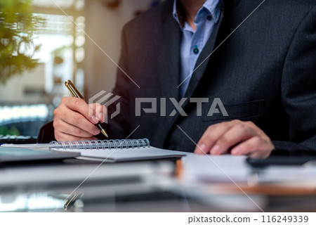man hands with pen writing on notebook in the office.learning, education and work.writes goals, plans, make to do and wish list on desk.. 116249339