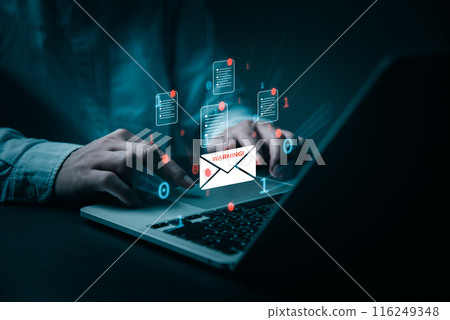 A person's hands are shown typing on a laptop, surrounded by digital email icons of documents and a warning sign. The image conveys a sense of urgency and attention to cybersecurity threats. A person's hands are shown typing on a laptop, surrounded by digital email icons of documents and a warning sign. The image conveys a sense of urgency and attention to cybersecurity threats. 116249348