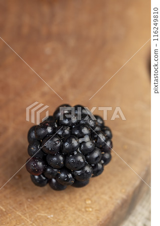 black ripe blackberries on the table in a wooden bowl black ripe blackberries on the table in a wooden bowl 116249810