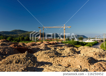 Construction area space with crane in valley against blue sky 116250452