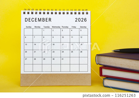 December 2026 calendar with yellow cover background and books. New month and calendar concept 116251263