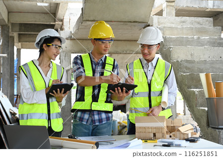 Engineers discussing about new project plan with architect at construction site 116251851
