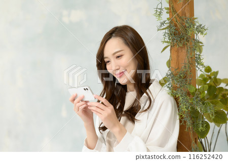 A woman watching a smartphone A woman watching a smartphone 116252420