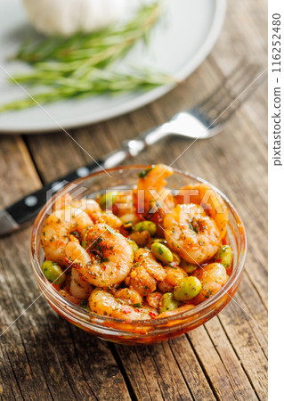 Fresh salad with shrimps and edamame soybeans in bowl on wooden table. 116252480