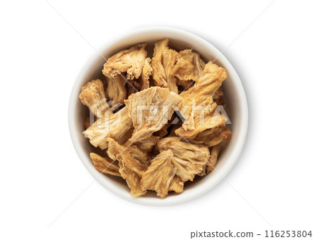 Ceramic bowl with sweet dried pineapple pieces isolated on white background. Ceramic bowl with sweet dried pineapple pieces isolated on white background. 116253804