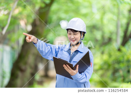 Women in work clothes, fresh green helmet Women in work clothes, fresh green helmet 116254584