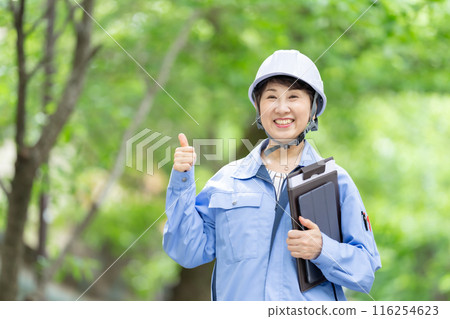 Women in work clothes, fresh green helmet, tablet 116254623