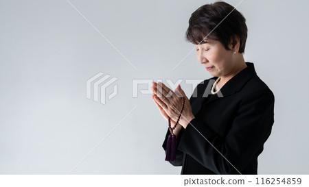 Woman in mourning clothes, funeral, praying 116254859