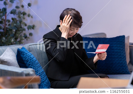 Woman in mourning clothes looking at bankbook Woman in mourning clothes looking at bankbook 116255031