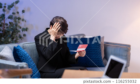 Woman in mourning clothes looking at bankbook Woman in mourning clothes looking at bankbook 116255032