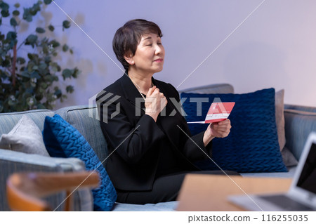 Woman in mourning clothes looking at bankbook 116255035