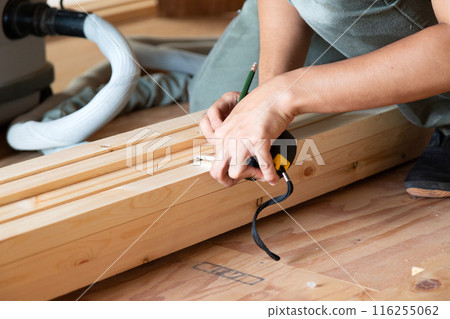 Carpenter working at a construction site of a new house Carpenter working at a construction site of a new house 116255062