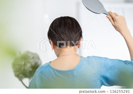 Woman putting on a wig, hair care, back view 116255291