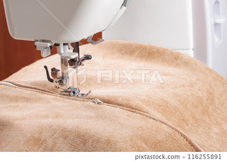 Modern sewing machine special presser foot with beige fabric and zipper, closeup Modern sewing machine special presser foot with beige fabric and zipper, closeup 116255891