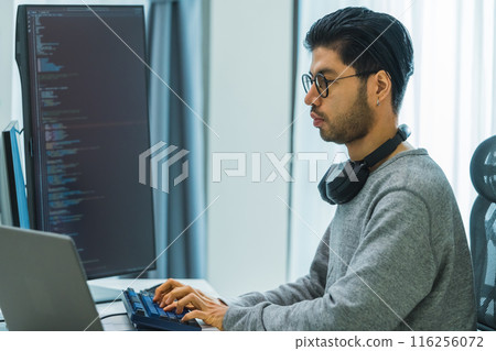 Asian man  prompt engineer develop coding app with software data sitting in front of computer monitor at office 116256072