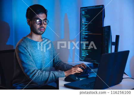 Indian software development working on coding  computer screen and flowchart at night in modern office 116256100