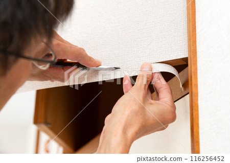 一位工匠正在重新覆蓋房屋的布料 116256452