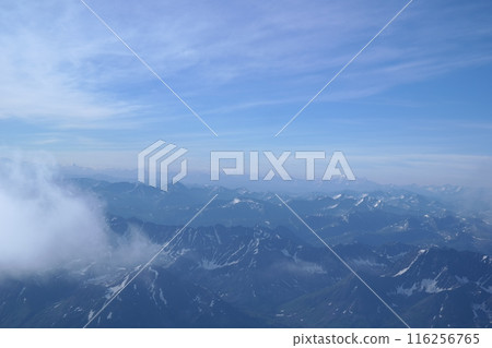 Tranquil Lake With Lush Green Forest, Snow-Capped Mountain, Blue Sky And White Clouds Tranquil Lake With Lush Green Forest, Snow-Capped Mountain, Blue Sky And White Clouds 116256765