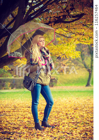Woman walking in park with umbrella 116257464