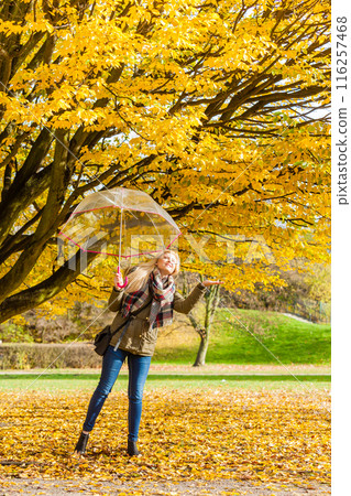 Woman walking in park with umbrella Woman walking in park with umbrella 116257468